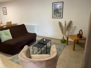 salon z kanapą i stołem w obiekcie Gîte La Hallette au cœur du vignoble Champenois, classé 2 étoiles w mieście Chouilly