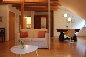 uma sala de estar com um sofá branco e uma mesa em Wohnung mit Dachterrasse in Starnberg em Starnberg