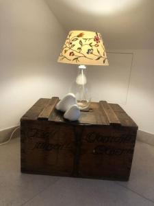 eine Lampe auf einer Holzkiste mit einem Tisch in der Unterkunft Wohnung mit Dachterrasse in Starnberg in Starnberg