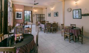 a restaurant with tables and chairs in a room at Cloud 9 - B&B in Kalimpong