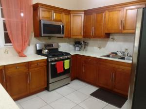 cocina con armarios de madera y horno con fogones en Abigail's Sunflower Entire 2 Bedroom Apt, en Tortola Island