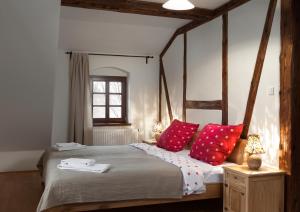 ein Schlafzimmer mit einem großen Bett mit roten Kissen in der Unterkunft Villa Greta in Schönau an der Katzbach