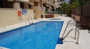 una gran piscina azul en un edificio en Andaluz Apartments Torrecilla, en Nerja
