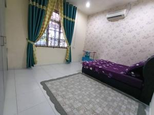 um quarto com uma cama roxa e uma janela em Homestay Kemaman Private Pool Fyna em Kampong Kemaman