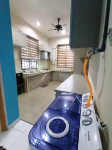 uma cozinha com um objecto azul no balcão em Homestay Kemaman Private Pool Fyna em Kampong Kemaman