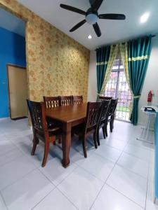 uma sala de jantar com uma mesa e cadeiras e uma ventoinha de tecto em Homestay Kemaman Private Pool Fyna em Kampong Kemaman