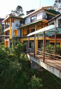 una casa grande con una terraza de madera frente a ella en Hotel Chautari pvt ltd, en Nagarkot