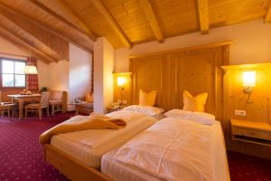 um quarto de hotel com duas camas e uma mesa em Berghotel Johanneshof em Anterselva di Mezzo