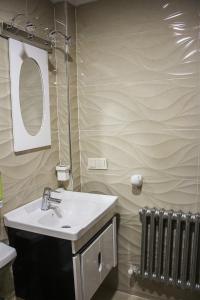 a bathroom with a sink and a mirror and a radiator at APPARTEMENT AMIRA iFRANE in Ifrane