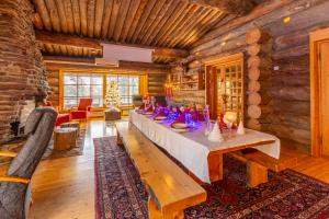 Kuukkeli Log Houses Aurora Resort في ساريسيلكا: غرفة طعام مع طاولة طويلة في كابينة