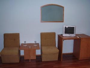 Zimmer mit 2 Stühlen und einem Tisch mit einem TV in der Unterkunft Prima Hotel in Kharmanli