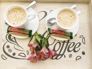 two cups of coffee and flowers on a table at @ Home Bed & Breakfast in Brakpan +32 photos