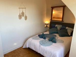 a bedroom with a bed with blue pillows on it at Les Mouettes in Ouistreham
