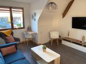 a living room with a blue couch and a tv at Les Mouettes in Ouistreham