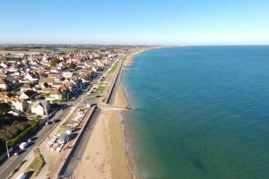 an aerial view of a beach with houses and the ocean at Les Mouettes in Ouistreham