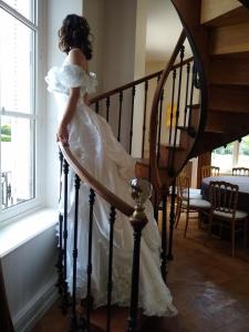 a bride walking down the stairs in her wedding dress at Domaine de la Vaudourière in Lunay