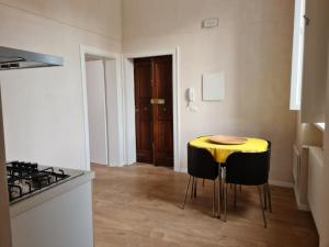 une cuisine avec une table jaune et deux tabourets dans l'établissement Al Palazzotto, à Lucera