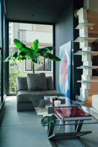 uma sala de estar com uma mesa de vidro e um sofá em M House Hotel em Milano Marittima