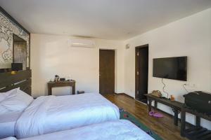 1 dormitorio con 2 camas y TV de pantalla plana en Lo Mustang Himalayan Resort, en Muktināth