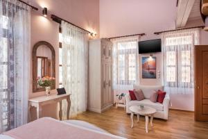 a bedroom with a bed and a couch and windows at Palazzo di Irene in Chania