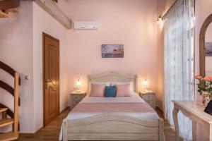 a bedroom with a bed with two tables and two lamps at Palazzo di Irene in Chania