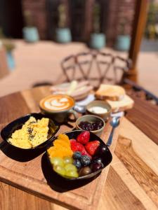 a tray with bowls of fruit on a table at Terra Firma Hotel Boutique in Villa Carlos Paz