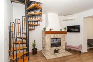 a living room with a fireplace and a spiral staircase at Apartment Molnar Crikvenica in Crikvenica