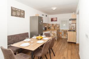 una cucina e una sala da pranzo con tavolo e sedie in legno di Apartment Molnar Crikvenica a Crikvenica