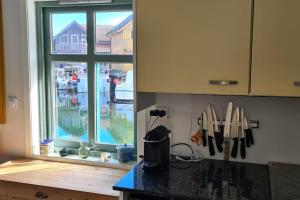 a kitchen with a window and a counter top with knives at Cottage 2 meters from the sea, Bekkjarvik, 60 km from Bergen 