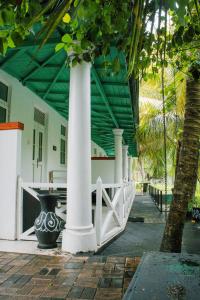 a building with white columns and a white fence at Villa Harbour View in Galle