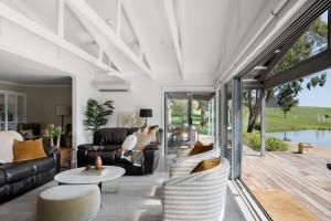 a living room with couches and a table at Headley Homestead - The Village Green in Strath Creek