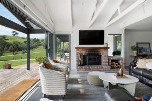 a living room with a fireplace and a tv at Headley Homestead - The Village Green in Strath Creek