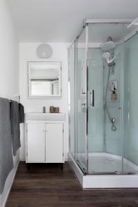 a bathroom with a glass shower and a sink at The Village Green Glampervans in Strath Creek