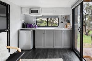 a kitchen in an rv with a window at The Village Green Glampervans in Strath Creek