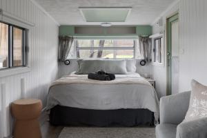 a bedroom with a bed with a stuffed animal on it at The Village Green Glampervans in Strath Creek