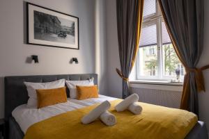 a bedroom with a bed with two pillows on it at Tyzenhauz Apartments Comfort in Kraków
