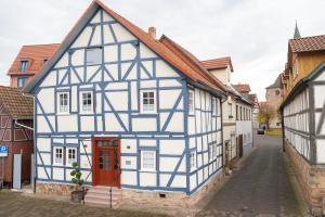 un edificio azul y blanco con una puerta roja en BACCO Bed & Breakfast, en Rotenburg an der Fulda