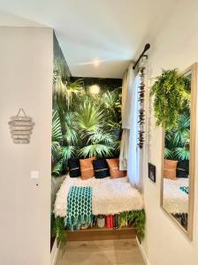 ein Schlafzimmer mit einem Wandbild aus Pflanzen in der Unterkunft Defoy Getaway - Antibes in Antibes