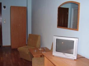 ein Wohnzimmer mit einem TV auf einem Holztisch in der Unterkunft Prima Hotel in Kharmanli