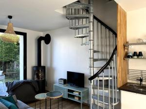 uma sala de estar com uma escada em espiral e um sofá em LA CABINE VUE MER em Luc-sur-Mer
