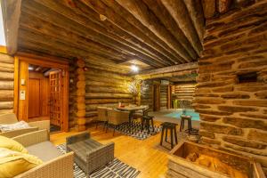 a log cabin living room with a stone wall at Kuukkeli Log Houses Aurora Resort in Saariselka