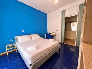 łóżko w pokoju z niebieską ścianą w obiekcie B&B Civico 40 w Mediolanie