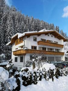 a building covered in snow with trees in the background at Apart Dahuam in Aschau