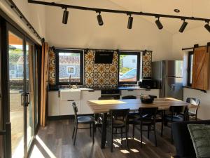 a kitchen and dining room with a table and chairs at Casa da Vinha Escondida AL in Biscoitos