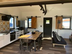 a kitchen and dining room with a wooden table and chairs at Casa da Vinha Escondida AL in Biscoitos