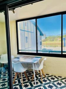 a table and chairs in a room with a window at Horizon Océan 1 - Superbe appartement 2 pièces avec parking privatif in Capbreton