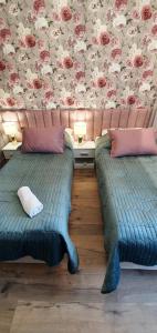 duas camas sentadas uma ao lado da outra num quarto em Willa Matejki em Przemyśl
