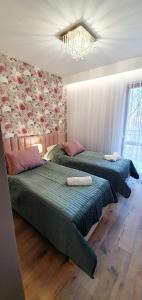 2 camas num quarto com um lustre em Willa Matejki em Przemyśl