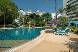 uma piscina com cadeiras e um guarda-sol em Patong Beach Gardens - Pool Fast WiFi Smart TVs em Praia de Patong