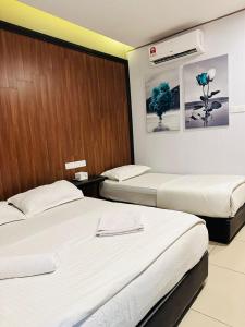 duas camas num quarto de hotel com lençóis brancos em Memory Boutique Hotel em Semporna